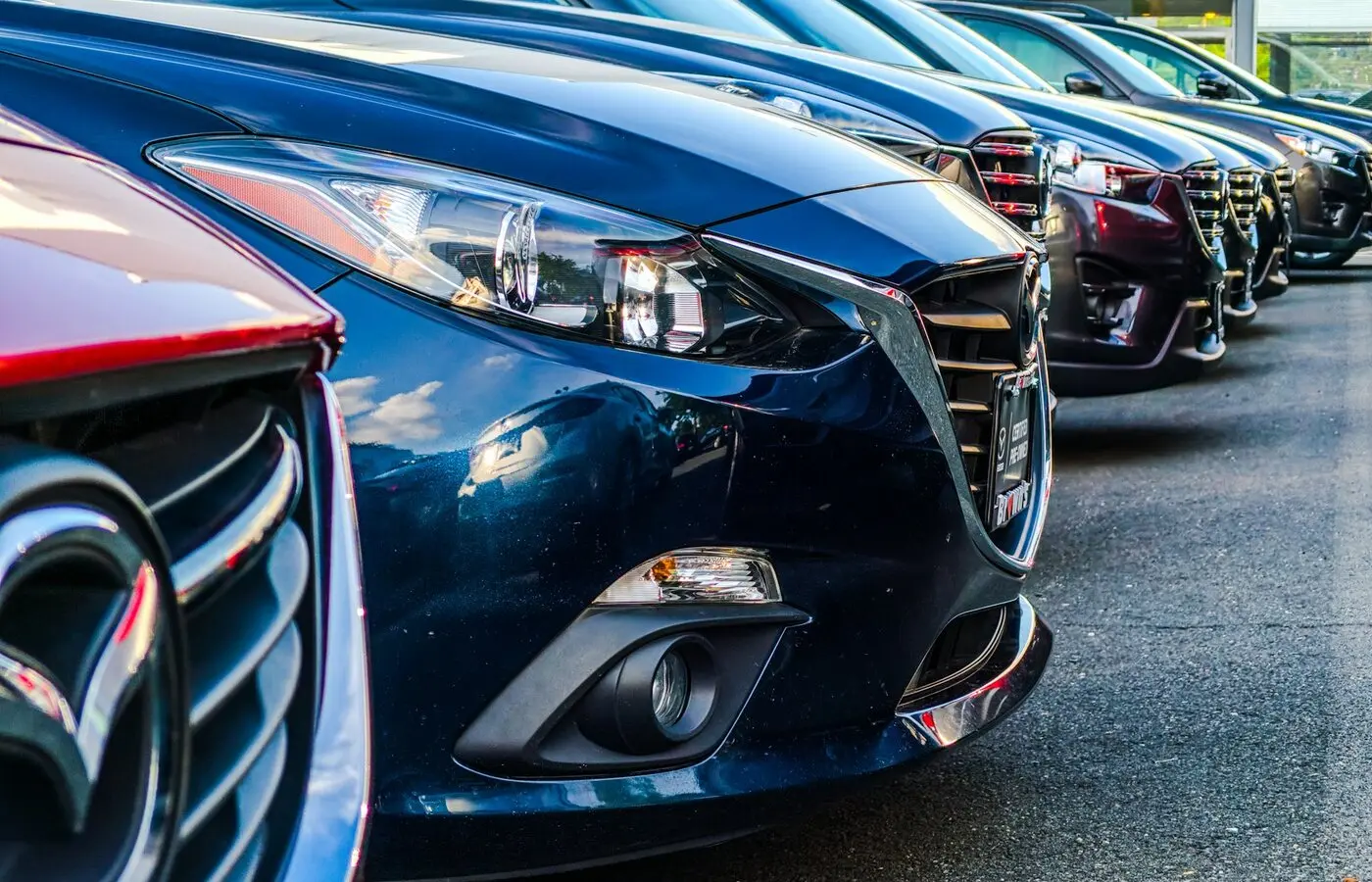 Modern UK taxi and private-hire fleet yard with clean hybrid and electric cars lined up