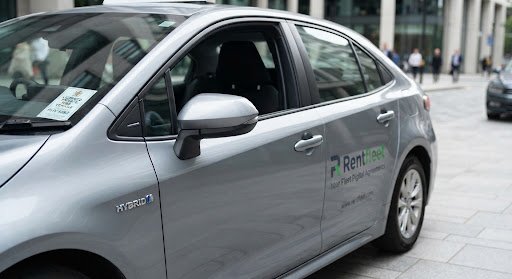 Close up photograph of driver side bodywork and doors of modern private hire Toyota hybrid taxi vehicle