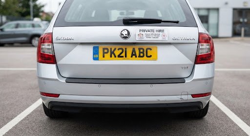 High resolution inspection photo of rear bumper and UK yellow registration plate on private hire taxi car